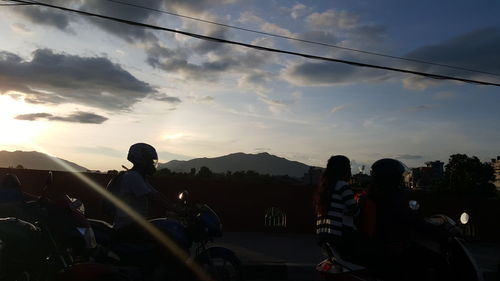 People on road against cloudy sky