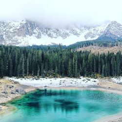 Scenic view of lake by snowcapped mountains during winter