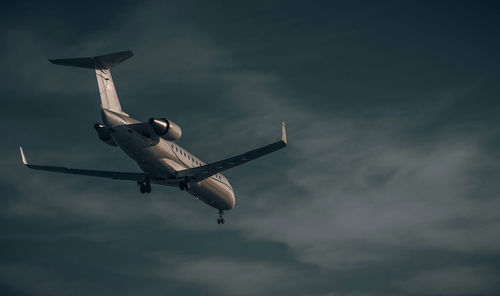 Low angle view of airplane flying against sky