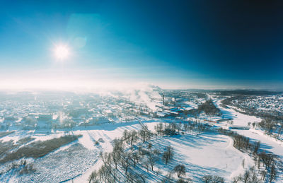 Aerial view of snow covered landscape against sky