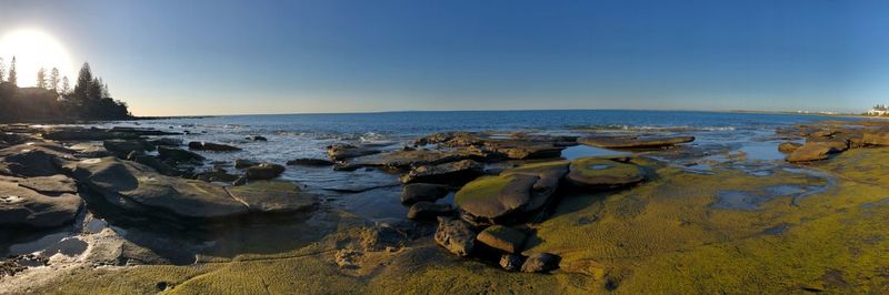 Rocks on beach against clear sky