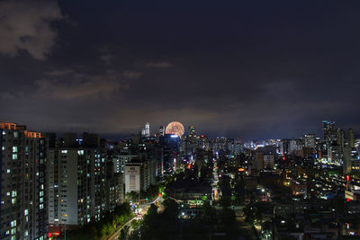 Illuminated cityscape against sky at night