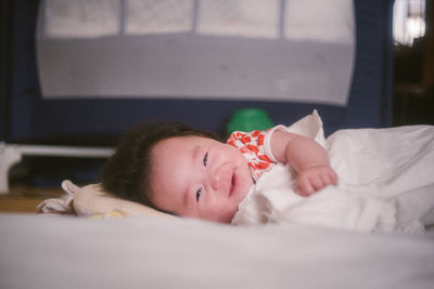 Portrait of girl lying on bed at home