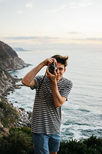 Full length of woman photographing in sea