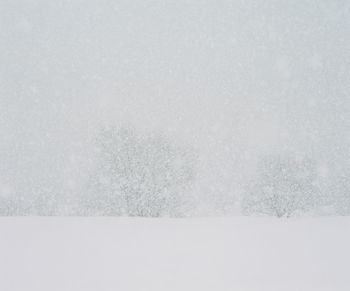 Snow covered field against clear sky