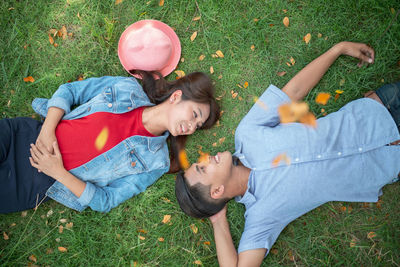 High angle view of friends lying on field