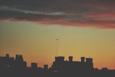 Silhouette of building against sky at sunset
