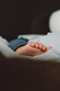 Low section of baby sleeping on bed