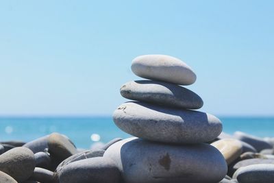 Stack of stones against clear blue sky