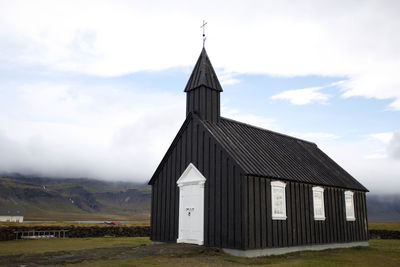 Built structure on field against sky