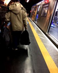Rear view of man standing at train