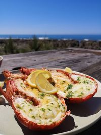 Close-up of food served in plate on beach against sky