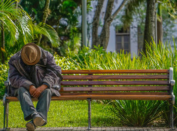 Tired man sitting on bench at public park