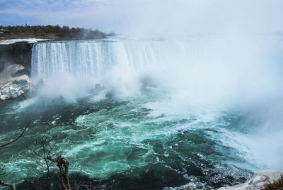 Scenic view of waterfall against sky