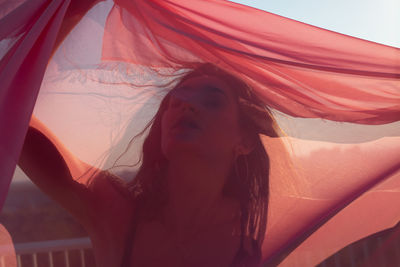 Close-up of young woman with pink scarf