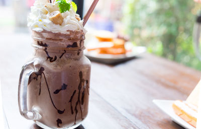 Chocolate frappe with whip cream on wood table
