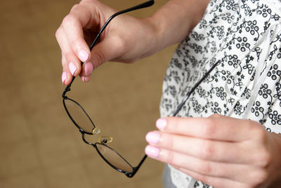 Midsection of woman holding eyeglasses