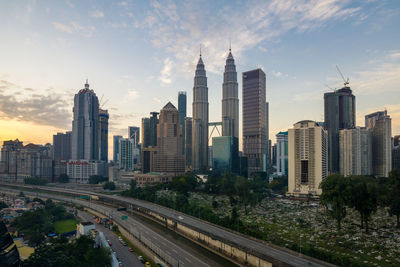 View of buildings in city against cloudy sky