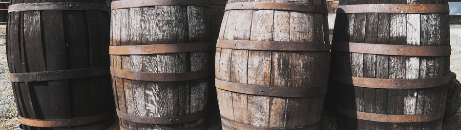 Old dirty weathered wooden barrels with rusty barrel hoops