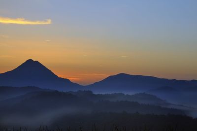 Scenic view of silhouette mountains against sky at sunset