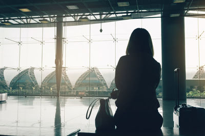 Rear view of woman standing at airport