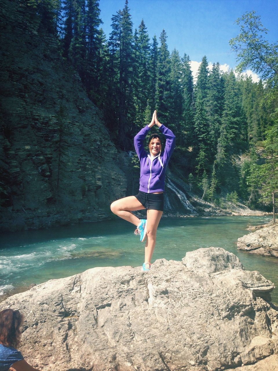 full length, lifestyles, leisure activity, water, tree, casual clothing, rear view, blue, standing, rock - object, tranquility, nature, person, tranquil scene, beauty in nature, vacations, day, sunlight