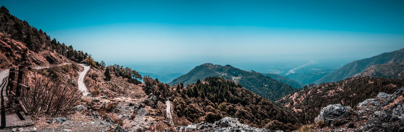 Panoramic view of mountains against blue sky