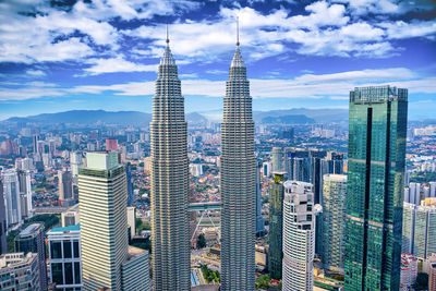 Modern buildings in city against cloudy sky