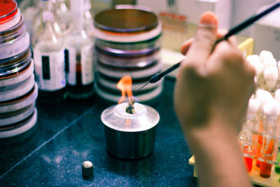 Midsection of person holding burning candles
