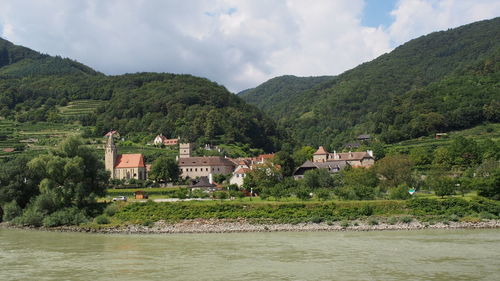 River by town against tree mountains