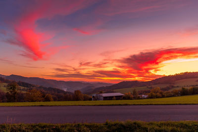 Scenic view of field against romantic sky at sunset