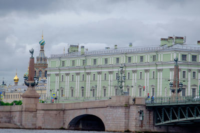 Buildings in city against cloudy sky