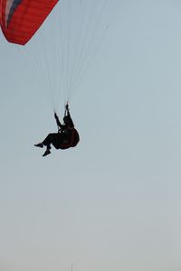 Low angle view of person paragliding against sky