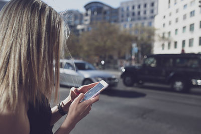 Close-up of woman using mobile phone on street