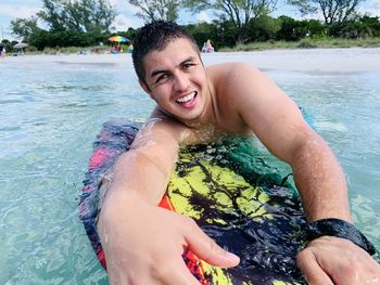 Portrait of smiling young man in beach pool