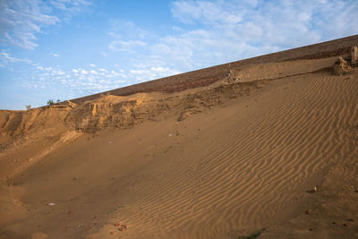 Sand dunes in desert against sky