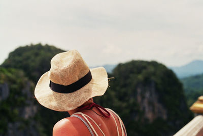 Rear view of woman with hat standing against sky