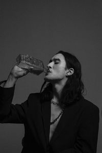 Side view of a young woman drinking glass