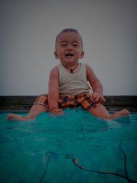 Portrait of cute boy standing in swimming pool