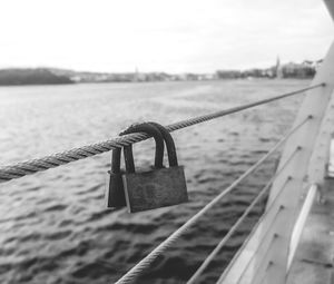 Close-up of padlocks on railing against river