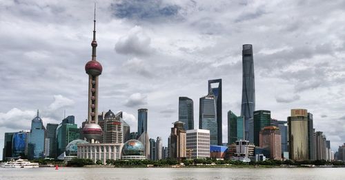 View of buildings in city against cloudy sky