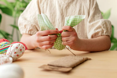 Making easter decorations. close-up of a girl's hands making textile easter egg a shape of bunny