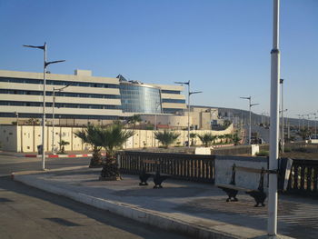 Street and buildings against clear blue sky