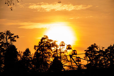 Silhouette trees against orange sky