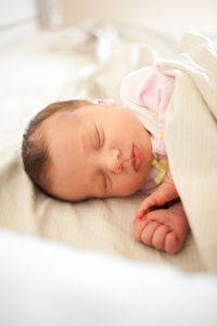 Newborn baby girl sleeping in bed.
