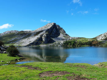 Scenic view of lake and mountains against blue sky