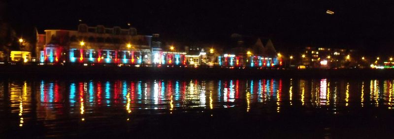 Illuminated reflection of water in sky at night