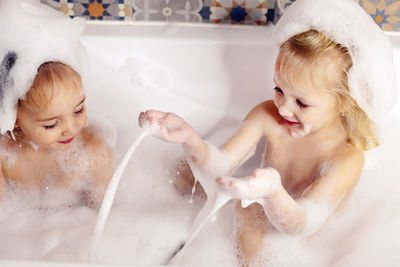 High angle view of woman washing hair in bathtub