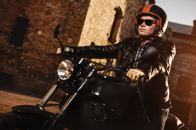 Man wearing helmet while sitting on motorcycle