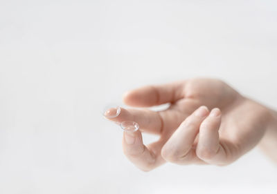 Close-up of hand holding baby over white background